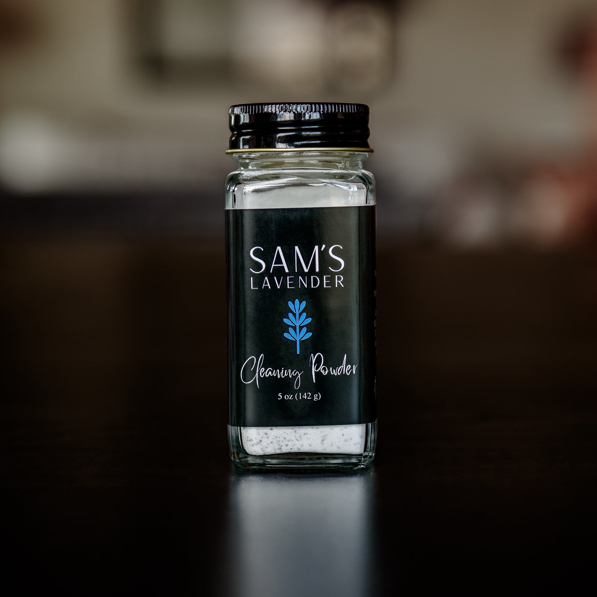 A clear glass jar labeled 'Sam's Lavender Cleaning Powder' with a black lid.