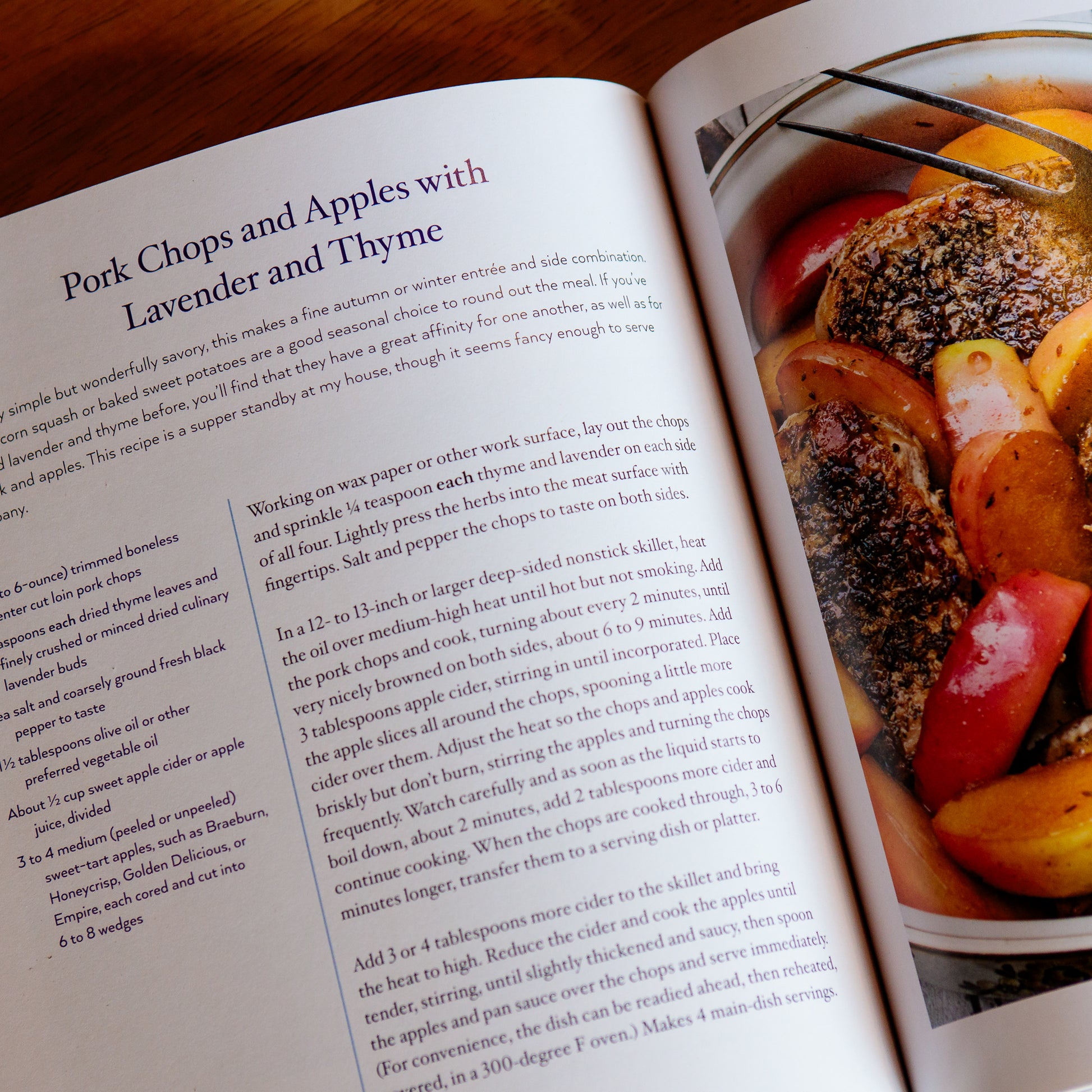 Open page of "The Art of Cooking with Lavender" cookbook showing a pork chops and apples recipe.