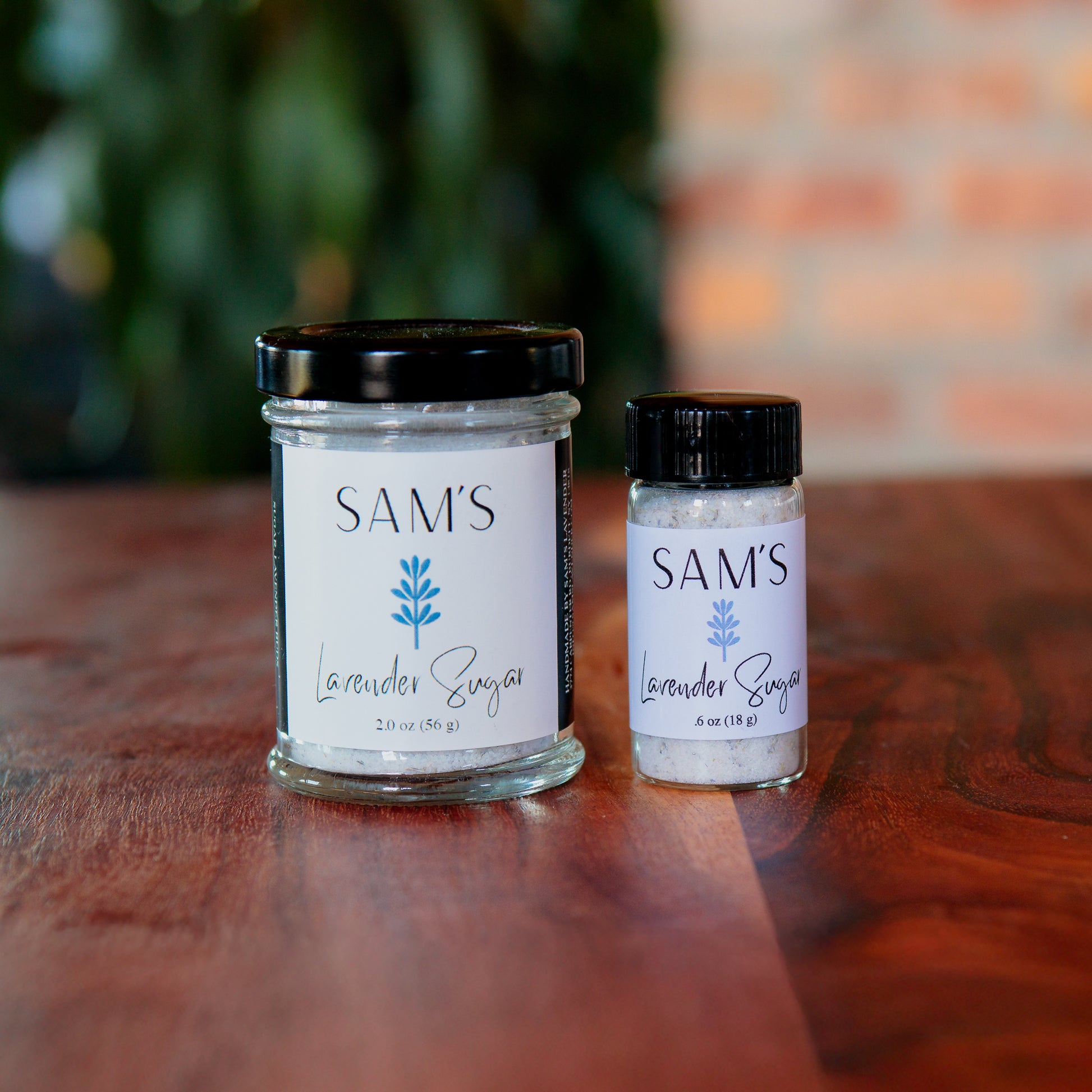 A 2oz glass jar and .6oz glass vial filled with culinary lavender sugar