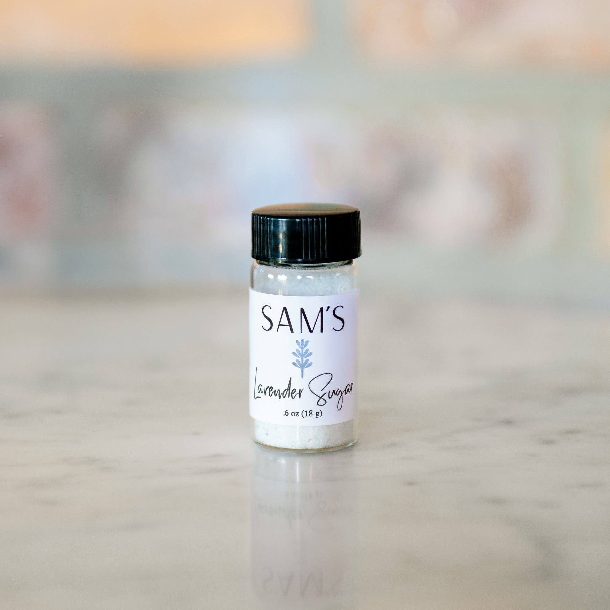 A glass jar labeled 'Sam's Lavender Sugar' filled with lavender sugar.