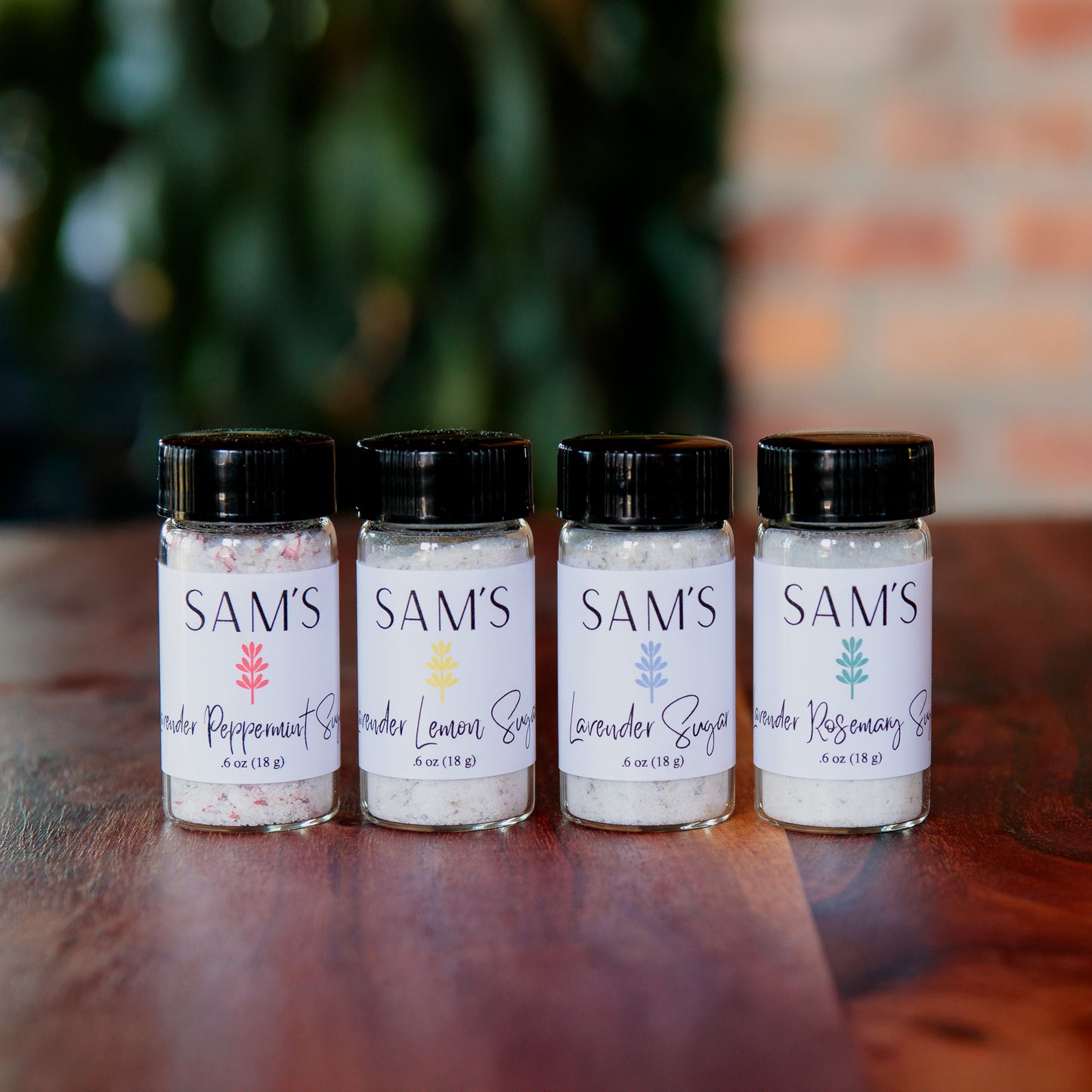 Four glass vials containing lavender sugar flavors - plain, lavender lemon, lavender peppermint, and lavender rosemary